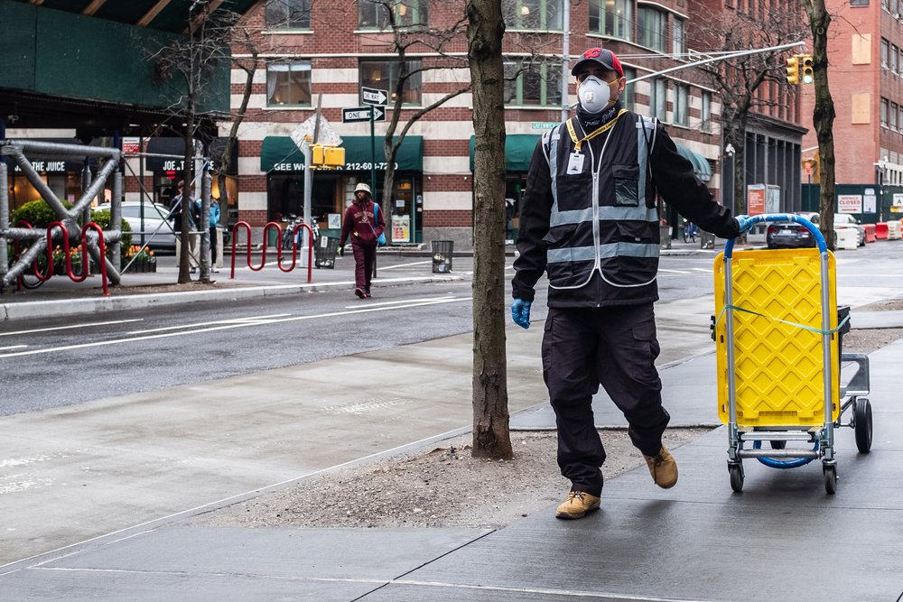 A worker pulling a yellow cart